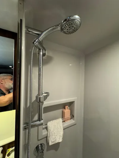  Yacht Photos Pics Shower area in 2023 Cruisers Yachts 46 Cantius, featuring modern fixtures and storage shelf.