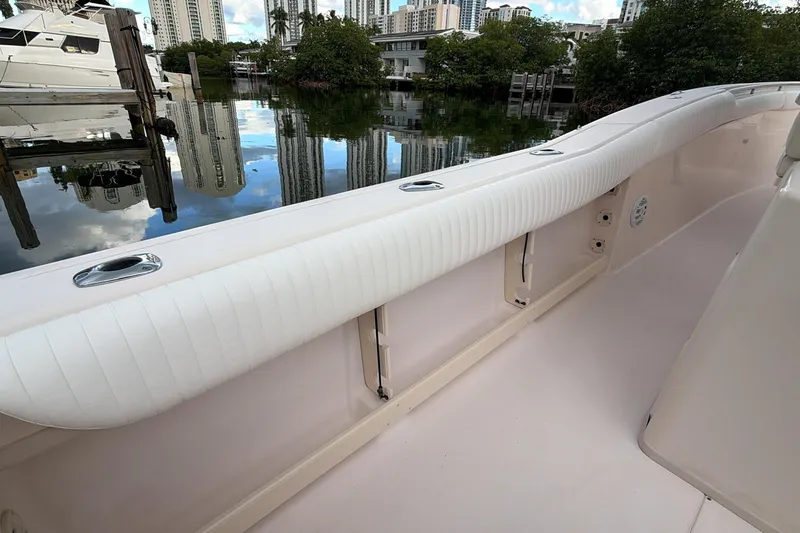  Yacht Photos Pics 2010 Grady-White Canyon 336 boat interior with white cushioned seating, docked near cityscape.