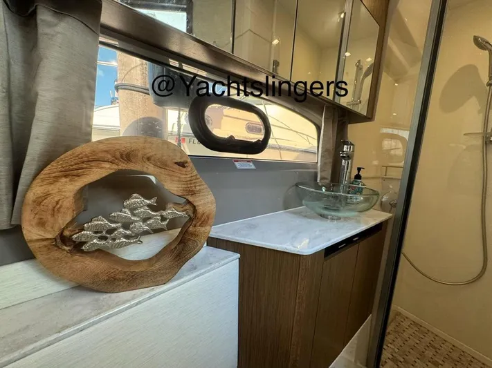  Yacht Photos Pics 2017 Sea Ray Sundancer bathroom with modern sink, decorative wood art, and glass shower.