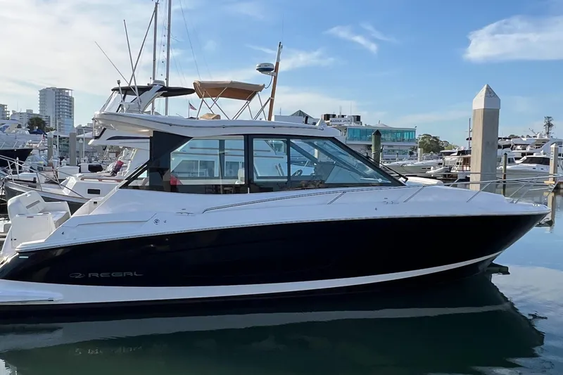 Y Knot Yacht Photos Pics 2021 Regal 36 Grande Coupe yacht docked in a marina, showcasing sleek design and modern features.