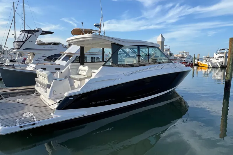 Y Knot Yacht Photos Pics 2021 Regal 36 Grande Coupe yacht docked in a marina under a clear blue sky.