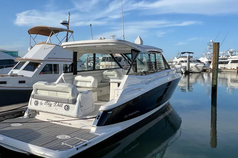 Y Knot Yacht Photos Pics 2021 Regal 36 Grande Coupe yacht docked in marina, featuring sleek design and spacious deck.