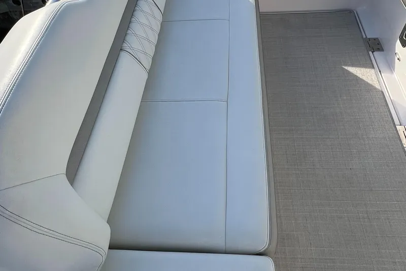 Y Knot Yacht Photos Pics 2021 Regal 36 Grande Coupe interior seating with light upholstery and textured flooring.
