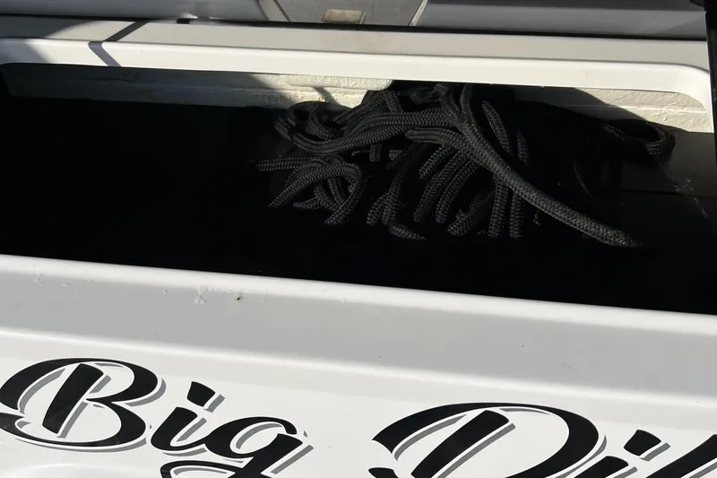 Y Knot Yacht Photos Pics 2021 Regal 36 Grande Coupe storage compartment with rope, featuring "Big D" lettering.