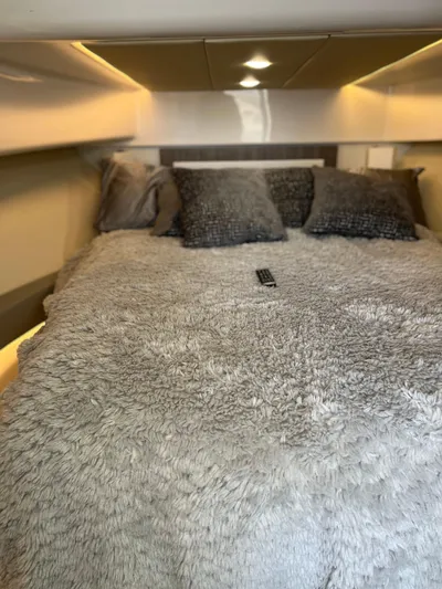 Y Knot Yacht Photos Pics Luxurious bedroom in 2021 Regal 36 Grande Coupe yacht with plush bedding and ambient lighting.