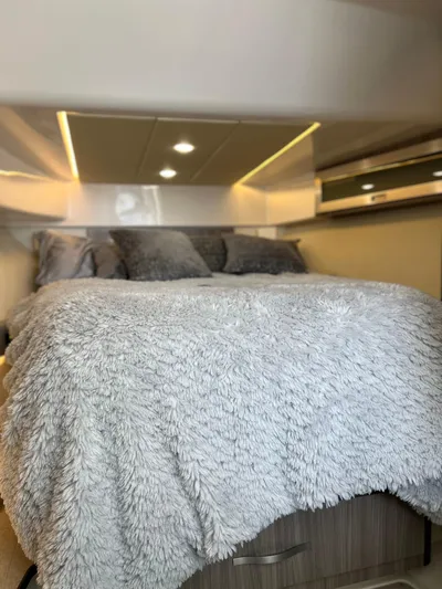 Y Knot Yacht Photos Pics 2021 Regal 36 Grande Coupe interior with cozy bed and modern lighting.