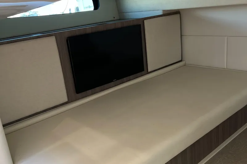 Y Knot Yacht Photos Pics Interior of 2021 Regal 36 Grande Coupe with a sleek TV and cushioned seating.