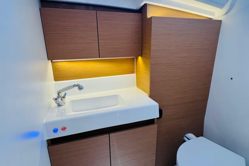 Pearl Yacht Photos Pics Modern bathroom interior of 2023 Jeanneau 380 yacht with sleek sink and wooden cabinetry.