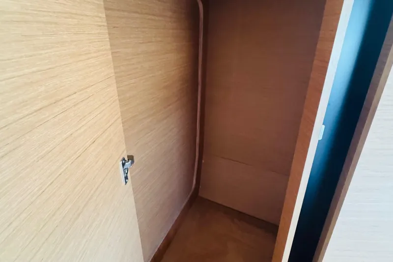 Pearl Yacht Photos Pics Interior storage space on 2023 Jeanneau 380 yacht, featuring wooden finish and door latch.