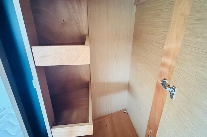 Pearl Yacht Photos Pics Wooden interior cabinet of 2023 Jeanneau 380 yacht, featuring shelves and hinge detail.