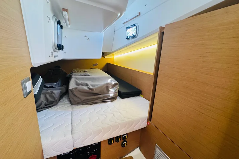 Pearl Yacht Photos Pics Cozy cabin interior of 2023 Jeanneau 380 yacht with modern wood finish and bedding.