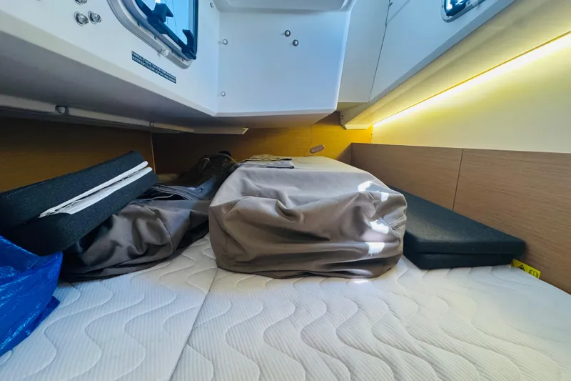 Pearl Yacht Photos Pics 2023 Jeanneau 380 cabin interior with storage and bedding, featuring modern design and lighting.