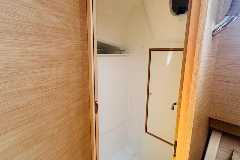 Pearl Yacht Photos Pics 2023 Jeanneau 380 yacht interior with wooden finish and compact bathroom.