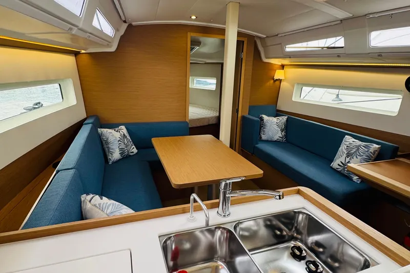 Pearl Yacht Photos Pics Modern interior of 2023 Jeanneau 380 yacht with blue seating and wooden accents.