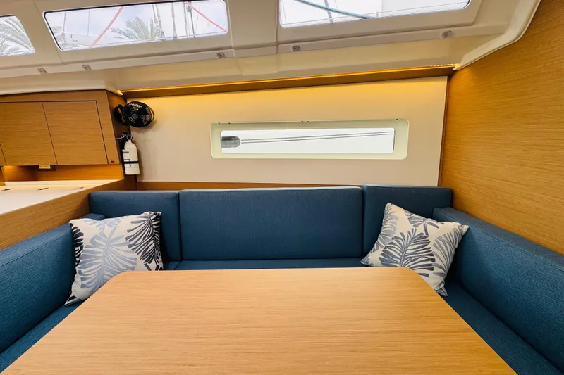 Pearl Yacht Photos Pics Interior of 2023 Jeanneau 380 yacht with blue seating and wooden table.