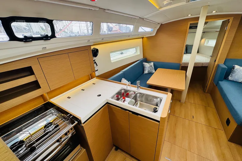 Pearl Yacht Photos Pics 2023 Jeanneau 380 yacht interior with modern kitchen, dining area, and cozy seating.