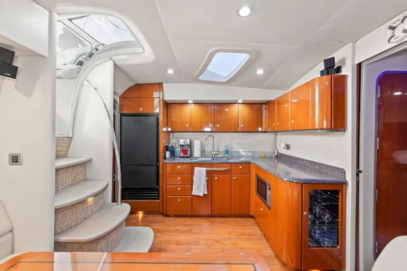 Hermes3 Yacht Photos Pics Luxurious kitchen interior of a 2007 Formula 45 Yacht with wooden cabinetry and modern appliances.