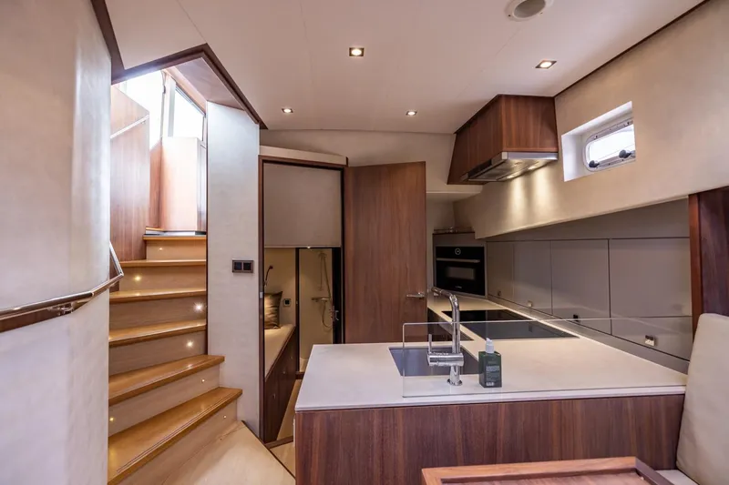 Wild Thing Yacht Photos Pics Modern kitchen interior of 2016 Explorer NG 50 Alu Fast Going yacht, featuring sleek wood finishes.