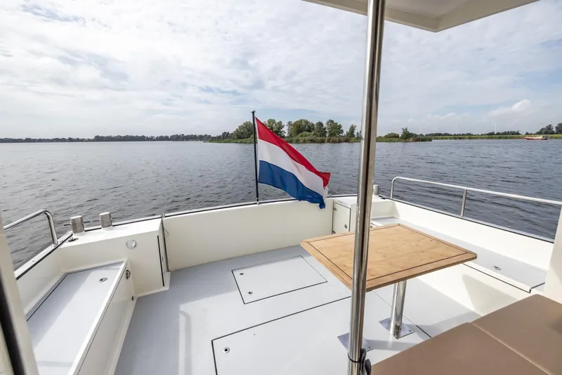Wild Thing Yacht Photos Pics Explorer NG 50 Alu Fast Going 2016 boat deck with Dutch flag on a serene lake.