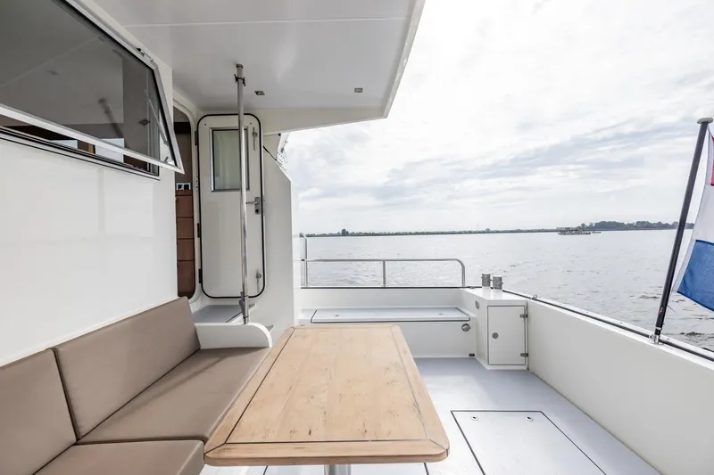 Wild Thing Yacht Photos Pics 2016 Explorer NG 50 Alu Fast Going yacht deck with seating and table, overlooking serene waters.