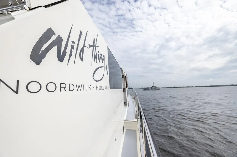 Wild Thing Yacht Photos Pics Explorer NG 50 Alu Fast Going yacht on water, "Wild Thing" branding, cloudy sky.
