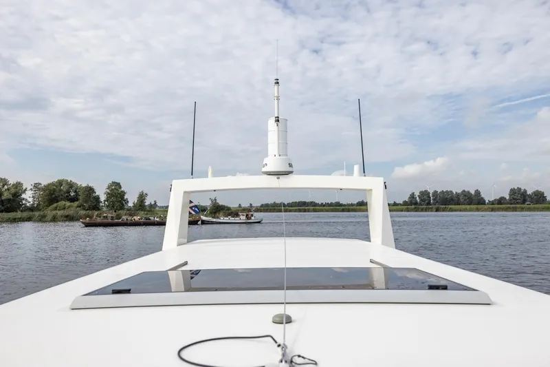 Wild Thing Yacht Photos Pics 2016 Explorer NG 50 Alu Fast Going boat on a calm river under a cloudy sky.