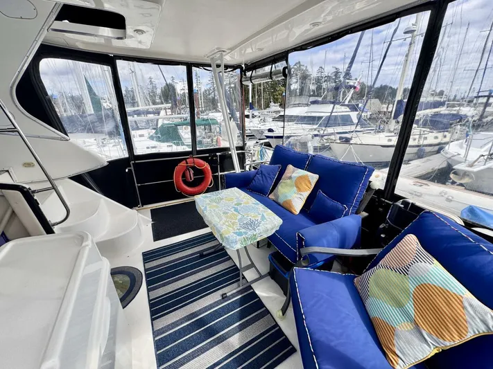  Yacht Photos Pics 1998 Bayliner 4087 Aft Cabin Motoryacht interior with blue seating, striped rug, and marina view.