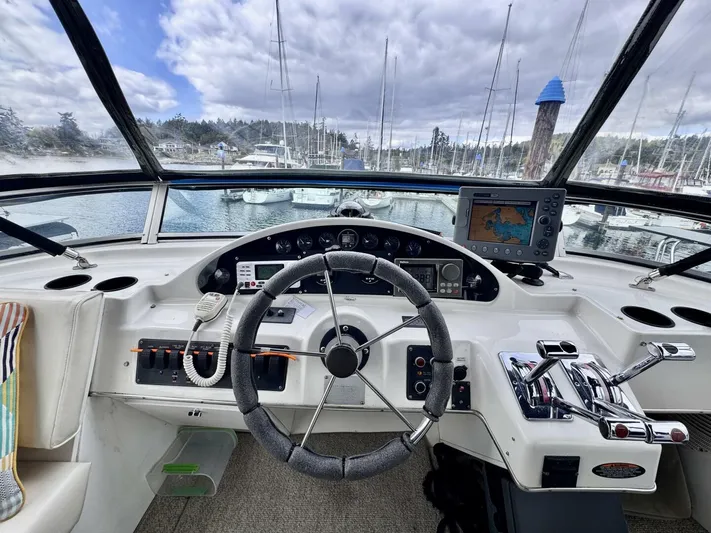  Yacht Photos Pics 1998 Bayliner 4087 Aft Cabin Motoryacht helm with steering wheel, controls, and navigation system.