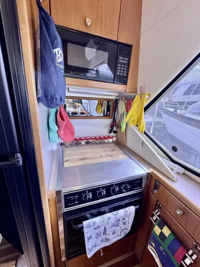  Yacht Photos Pics 1998 Bayliner 4087 Aft Cabin Motoryacht kitchen with stove, microwave, and window view.