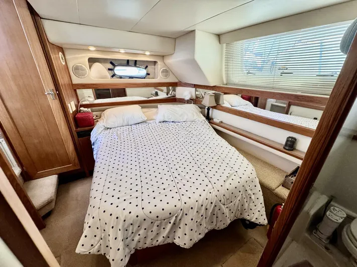  Yacht Photos Pics 1998 Bayliner 4087 Aft Cabin Motoryacht bedroom with polka dot bedding and wooden accents.