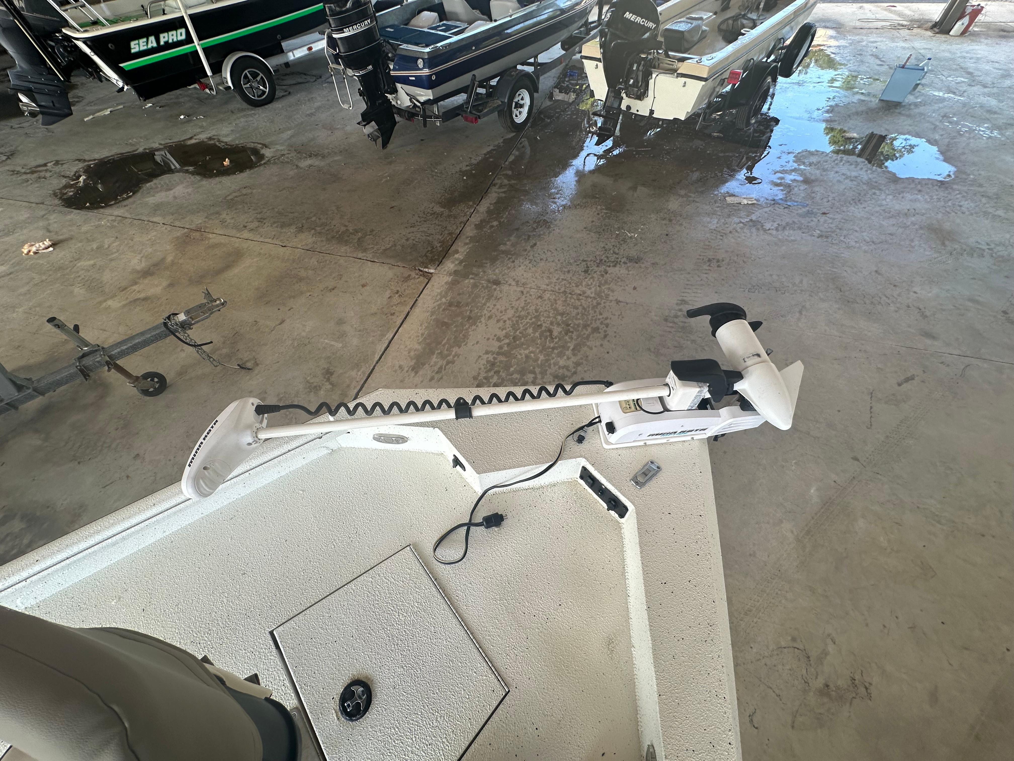 2018 Excel 220 Bay Pro boat with trolling motor in a garage setting.