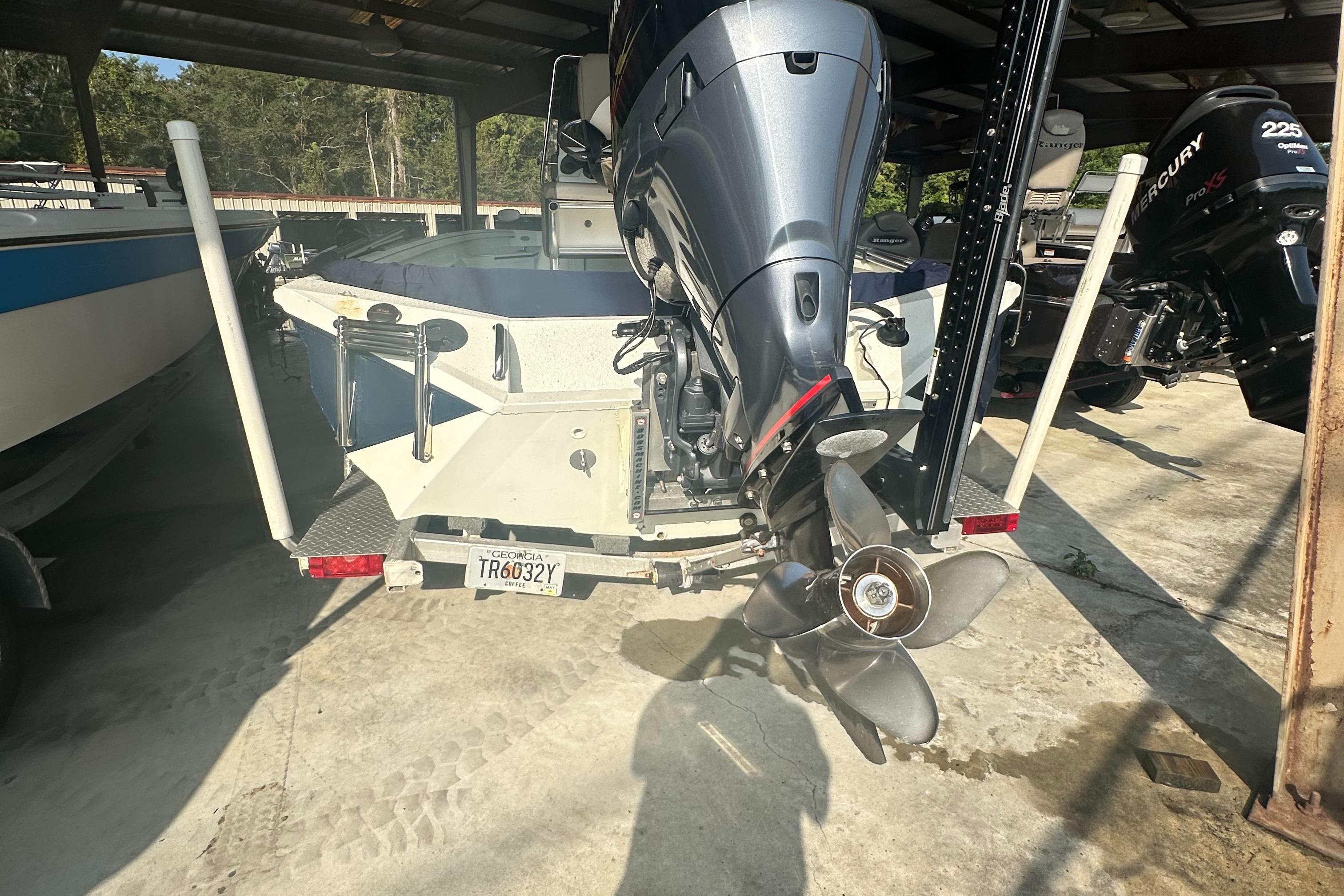 2018 Excel 220 Bay Pro boat with powerful outboard motor in storage.