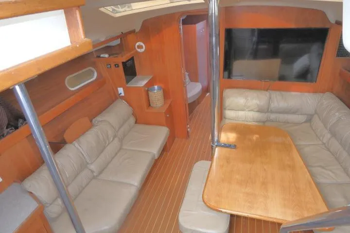 Interior of 1999 Hunter 450 Passage yacht with leather seating and wooden table.