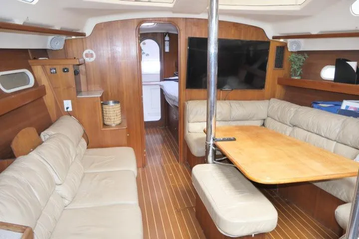 Interior of 1999 Hunter 450 Passage yacht with wood paneling and beige seating.