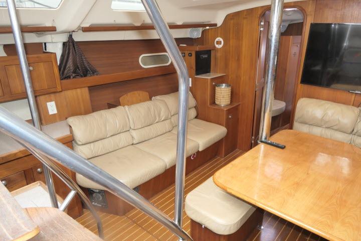 Interior of 1999 Hunter 450 Passage yacht with wooden furnishings and beige seating.