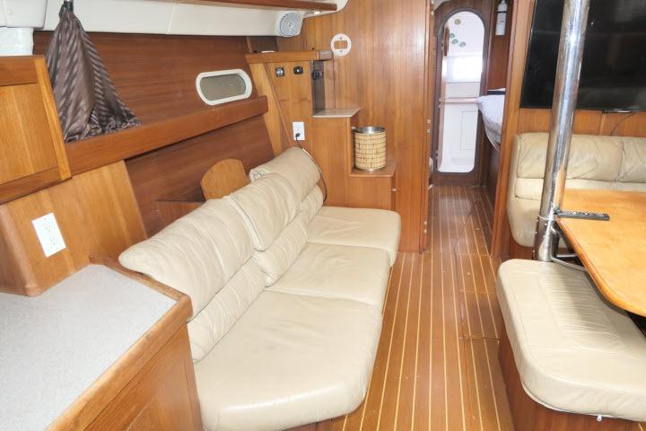 Interior of 1999 Hunter 450 Passage yacht with wooden finish and beige seating.