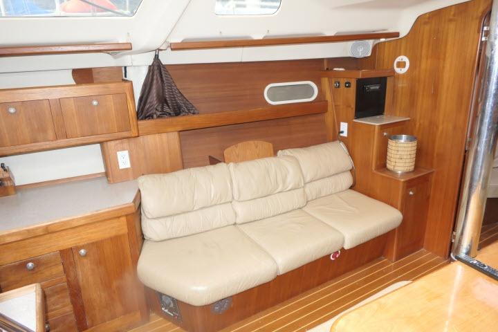 Interior of 1999 Hunter 450 Passage yacht with beige leather sofa and wooden cabinetry.