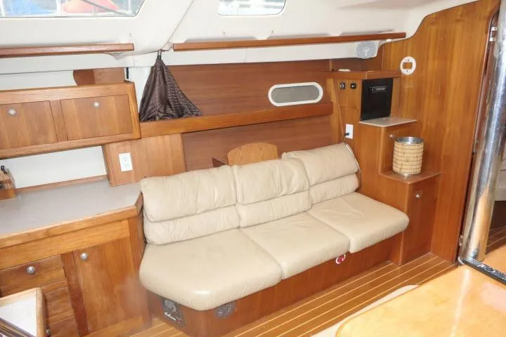 Interior of 1999 Hunter 450 Passage yacht with beige leather sofa and wooden cabinetry.