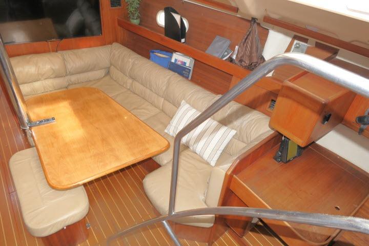 Interior of 1999 Hunter 450 Passage yacht with wooden table and beige seating.