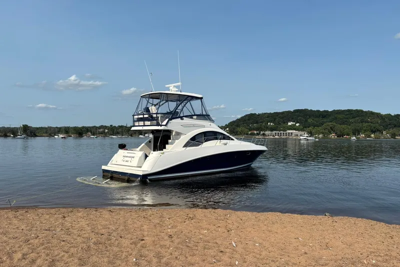 Shenanhiggins Yacht Photos Pics 2008 Sea Ray 47 Sedan Bridge yacht anchored near a sandy shore on a sunny day.