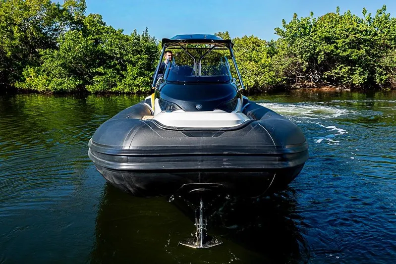  Yacht Photos Pics 2025 SACS Strider 11 navigating through calm waters, surrounded by lush greenery.