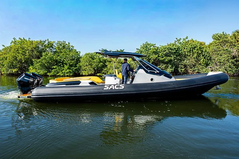  Yacht Photos Pics 2025 SACS Strider 11 boat cruising on a calm river with lush greenery.