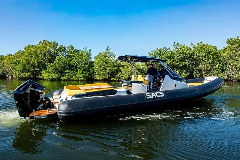  Yacht Photos Pics 2025 SACS Strider 11 boat cruising on a calm waterway, surrounded by lush greenery.
