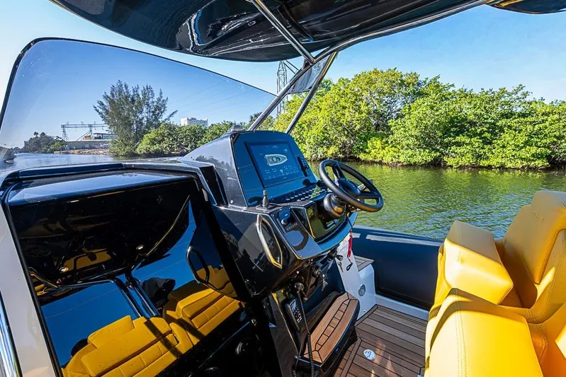 Yacht Photos Pics 2025 SACS Strider 11 boat cockpit with modern controls and yellow seating on a sunny day.