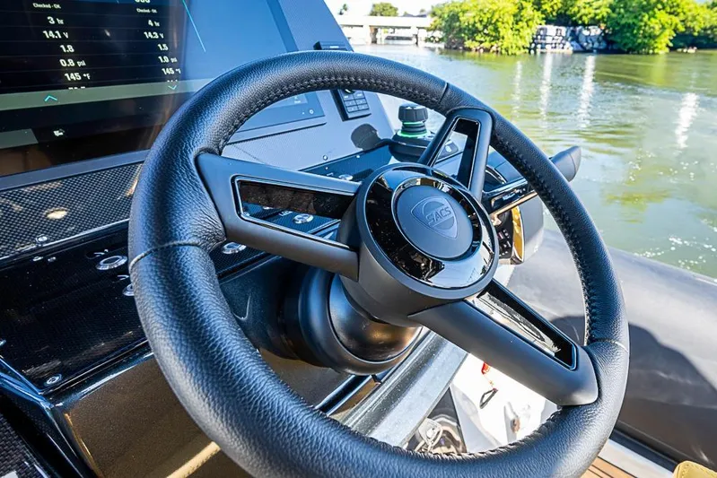  Yacht Photos Pics Steering wheel of 2025 SACS Strider 11 boat, with dashboard and water view.