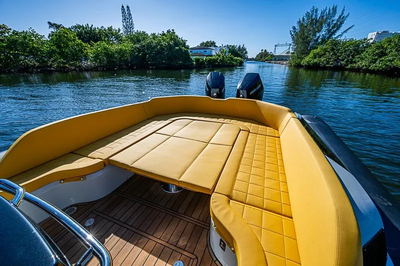  Yacht Photos Pics 2025 SACS Strider 11 boat with luxurious yellow seating on a serene waterway.