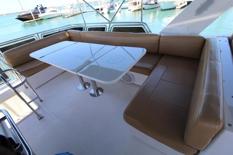  Yacht Photos Pics Bayliner 4788 Pilothouse Motoryacht 2000 with spacious outdoor seating and table, docked at marina.