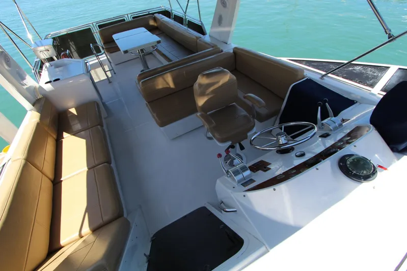  Yacht Photos Pics 2000 Bayliner 4788 Pilothouse Motoryacht interior with seating and helm, on calm water.