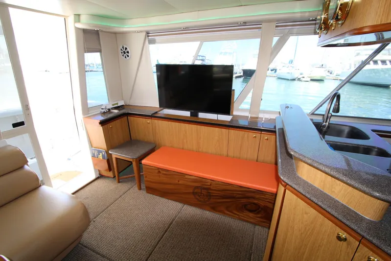  Yacht Photos Pics Interior of 2000 Bayliner 4788 Pilothouse Motoryacht with TV, seating, and waterfront view.