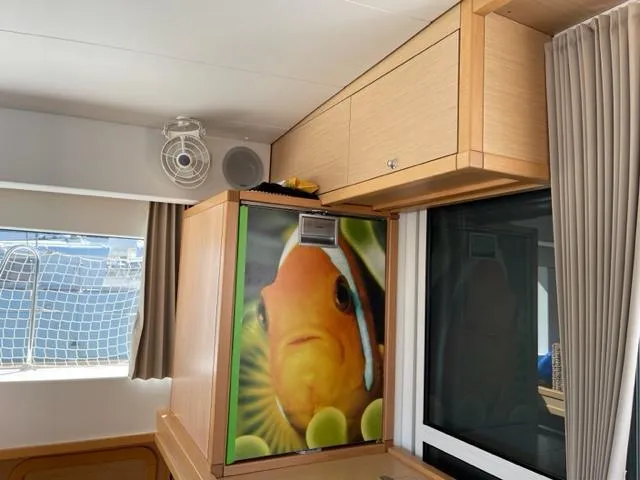 My Way Yacht Photos Pics Interior of 2017 Lagoon 39 yacht with fish-themed refrigerator and wooden cabinetry.